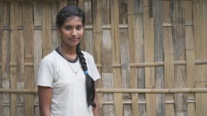 Chandrika standing in front of her house posing for the camera. 