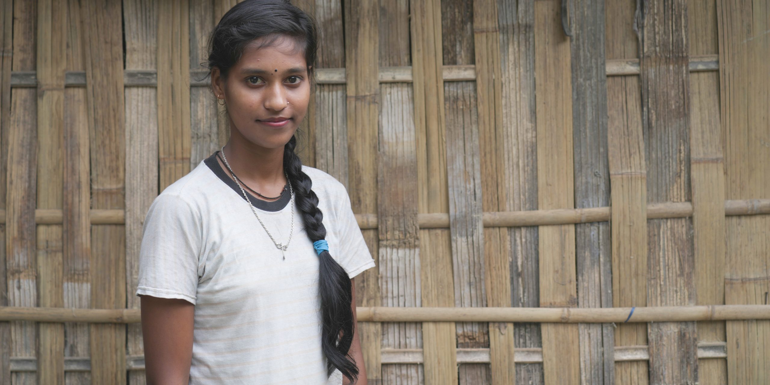 Chandrika standing in front of her house posing for the camera.